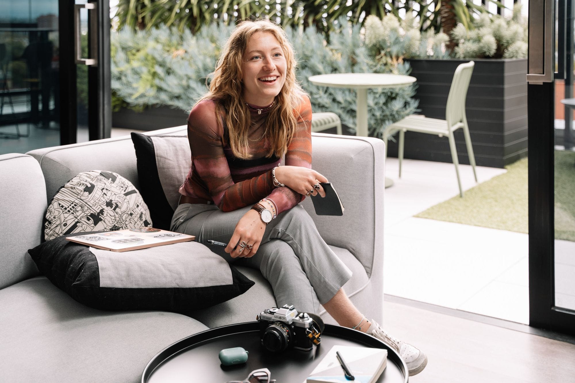 Smiling person relaxing on outdoor sofa.