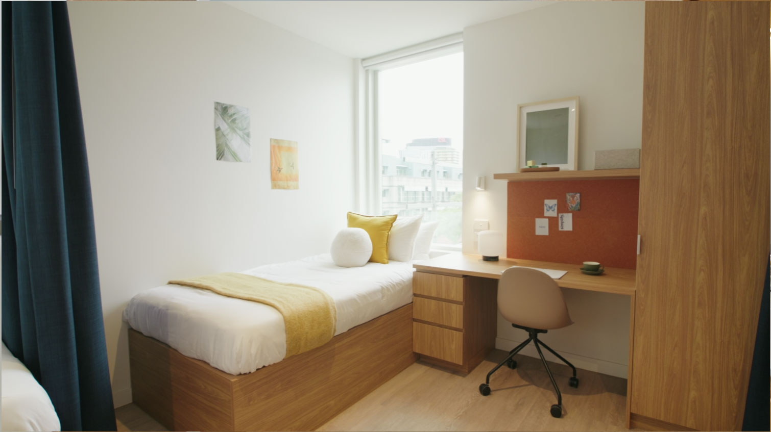 小卧室里有一张单人床、书桌和来自大窗户的自然光。